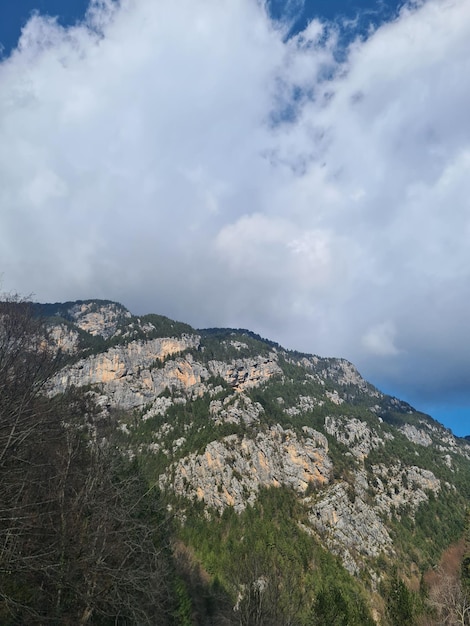 Una montaña con un cielo azul y nubes.