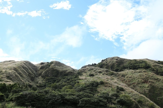 Una montaña con un cielo azul y nubes.