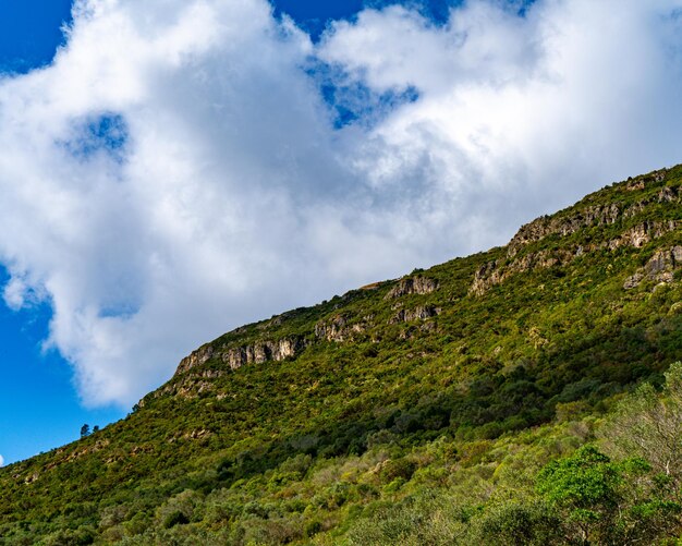 Una montaña con un cielo azul y nubes.