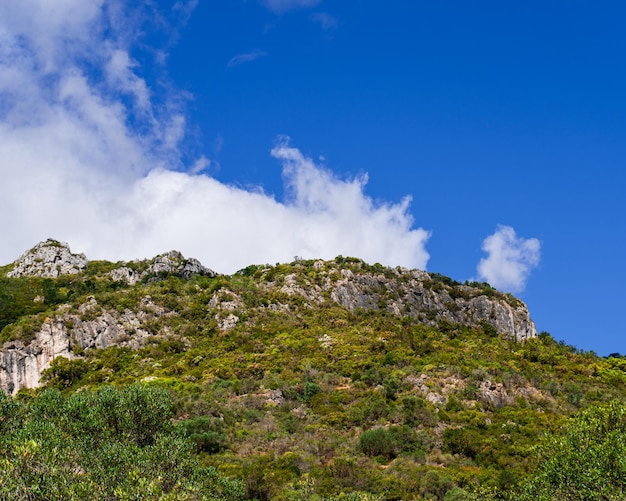 Una montaña con un cielo azul y nubes.