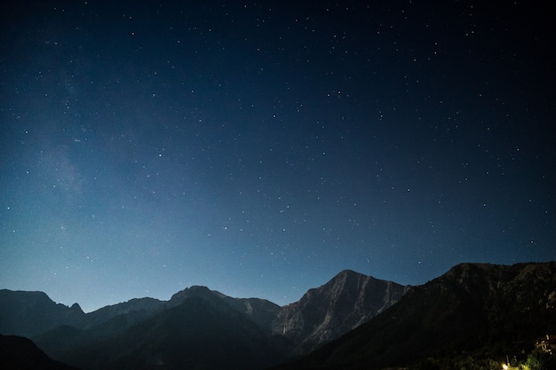 Montaña bajo el cielo y comienza en la noche.