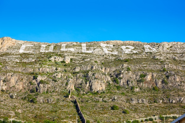 Montaña de Cullera con letrero blanco escrito en.