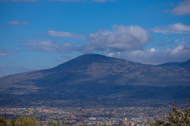 Foto una montaña está en el fondo con un cielo azul y nubes