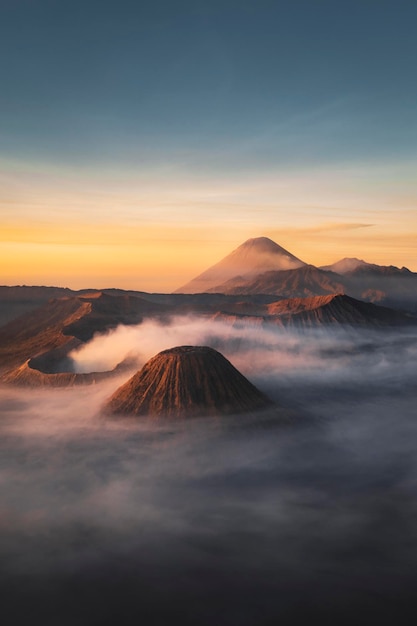 Foto una montaña está en el fondo de una puesta de sol