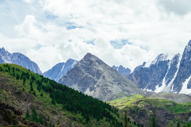 Montaña gigante de forma piramidal cerca de montañas nevadas.