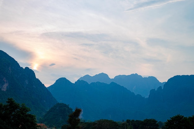 Montaña mientras se pone el sol Pico de la montaña paisaje natural verde Hermosa puesta de sol sobre la cordillera en vang vieng