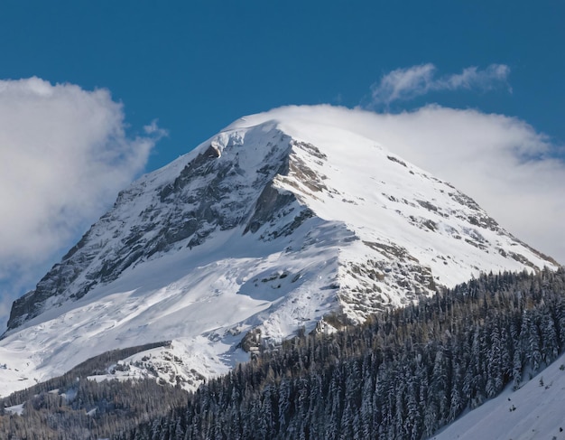 Foto una montaña con una montaña en el fondo y un cielo azul con nubes