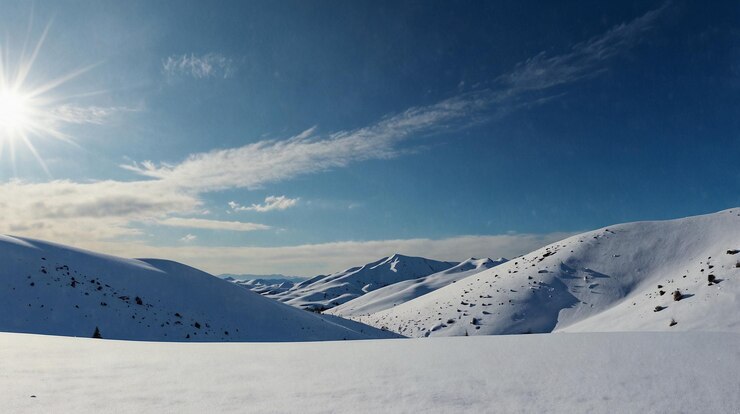 una montaña nevada con un cielo azul y una montaña en el fondo