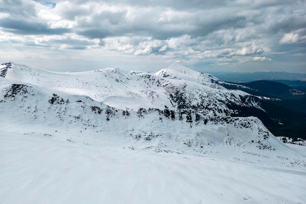 Una montaña nevada con un cielo nublado al fondo