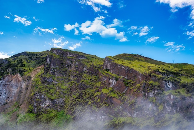 Montaña con niebla en el cielo azul con nubes en la mañana