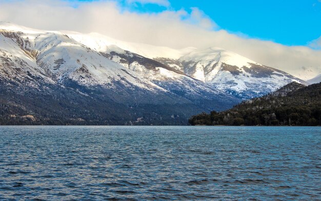 Foto una montaña con nieve y un cielo azul con una montaña en el fondo