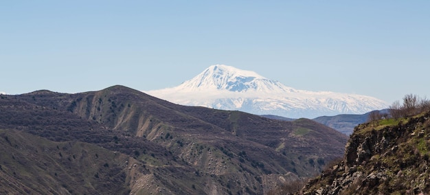 Una montaña con nieve y un cielo azul.