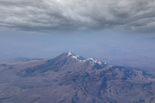 Una montaña con nieve y un cielo nublado