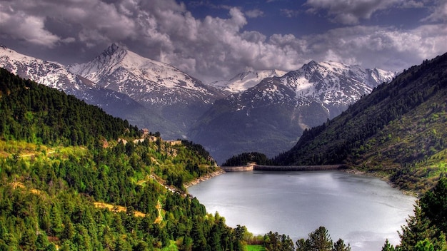 una montaña con nieve y un lago en el fondo