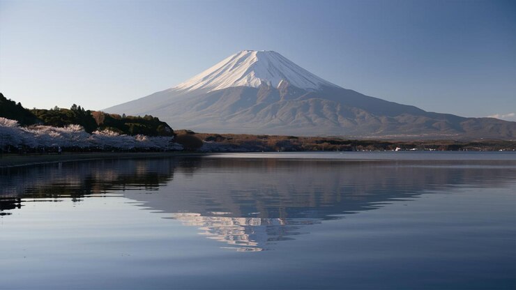 una montaña se refleja en el agua con un reflejo de ella