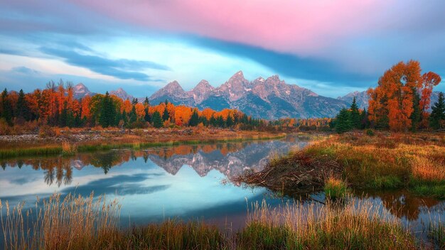 una montaña se refleja en un lago con los colores del otoño