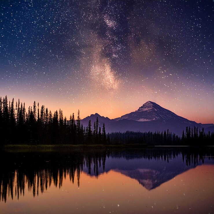 una montaña se refleja en un lago con una montaña en el fondo
