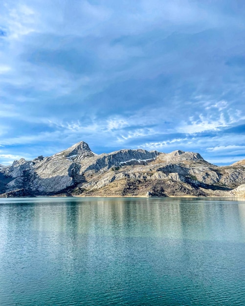 Montaña reflejada en el lago con nieve y frío.