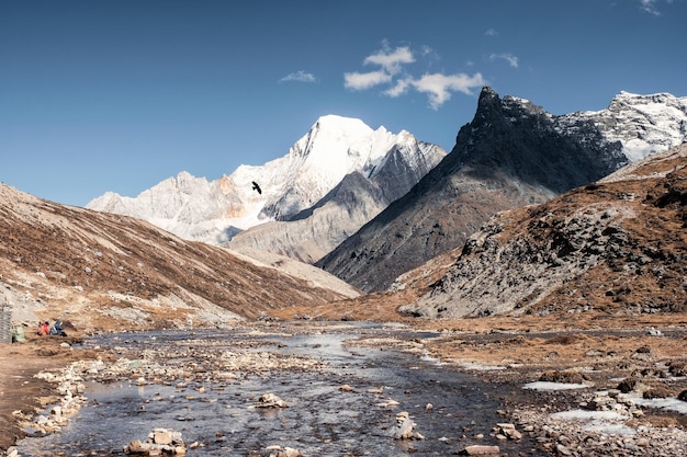 Montaña rocosa con río que fluye y cielo azul cerca del lago Milk