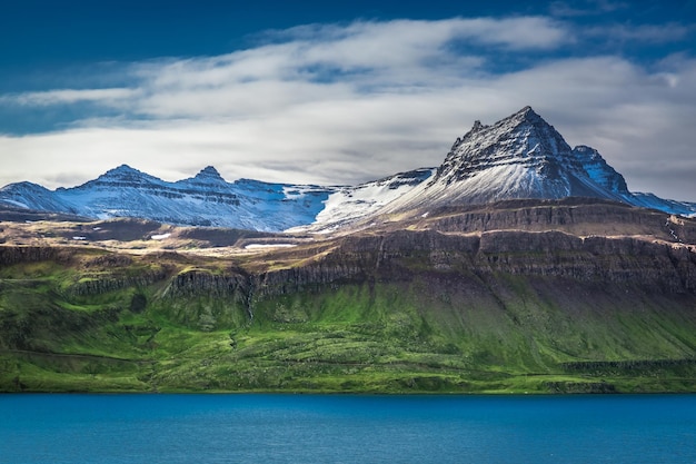 Montaña volcánica sobre fiordo en Islandia en verano