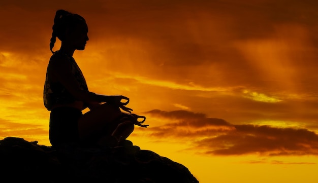 Montaña de yoga y meditación con silueta de mujer al atardecer para paz mental y zen en la naturaleza Paisaje de libertad y energía con chica relajarse después de caminar por salud, bienestar y motivación