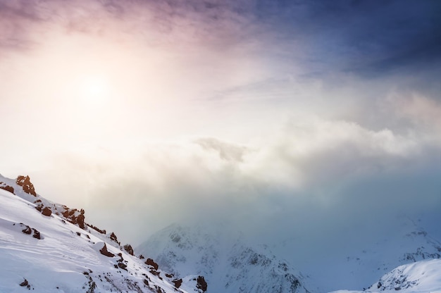 Montañas cubiertas de nieve al atardecer. Hermoso paisaje de invierno.