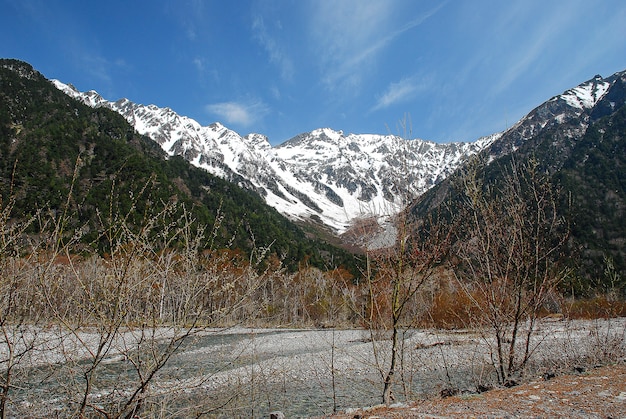 Montañas cubiertas de nieve en el fondo y lago claro en escena de invierno en Kamikochi, Japón