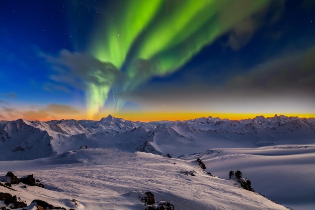 Montañas cubiertas de nieve en la noche bajo la aurora boreal Noruega