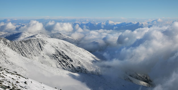 En las montañas por encima de las nubes. Laderas y picos nevados.