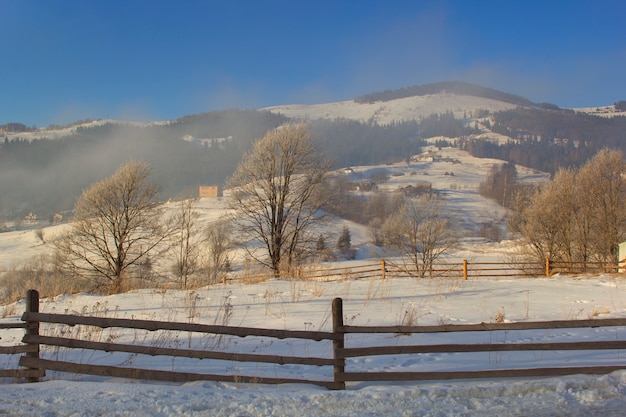 Montañas en invierno, vista a través de la valla.