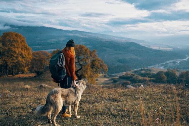 Montañas de naturaleza mujer excursionista viajan junto a la amistad de libertad de perro