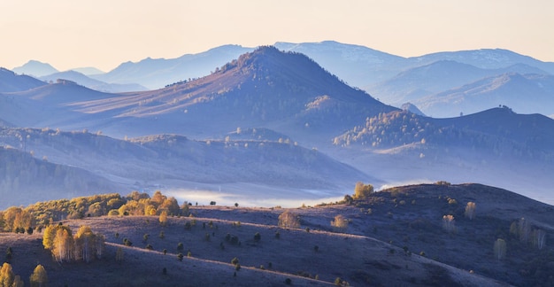 Montañas en la neblina de la mañana otoño