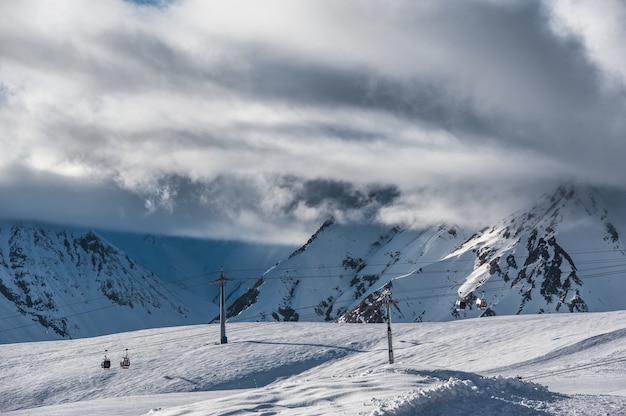 Montañas nevadas de invierno en día de sol. Montañas del Cáucaso, Georgia, desde la estación de esquí Gudauri