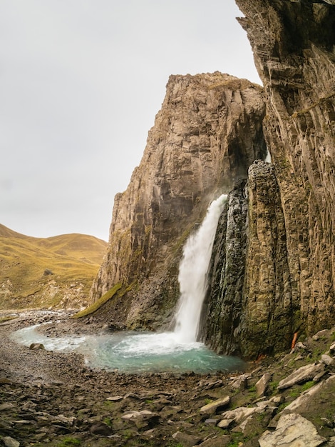 Montañas de otoño en la mañana de otoño GilSu cascada en el amplio valle de otoño en el norte del Cáucaso Rusia Hermoso paisaje vertical