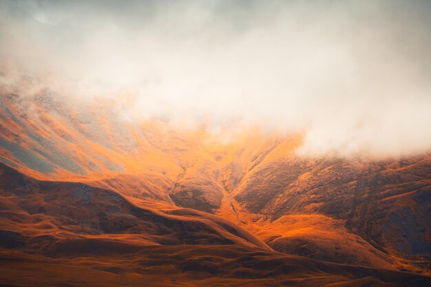 Montañas de otoño con niebla matutina al amanecer Nubes sobre las montañas y colinas amarillas Valle de GilSu en el norte del Cáucaso Rusia