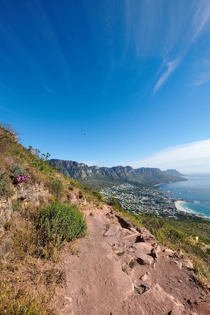 Montañas paisajísticas y parapente sobrevolando la ciudad del mar en un deporte extremo de adrenalina o un pasatiempo de aventura Copie el espacio azul cielo y vista al mar de la ruta de senderismo de montaña con rocas en el destino de viaje