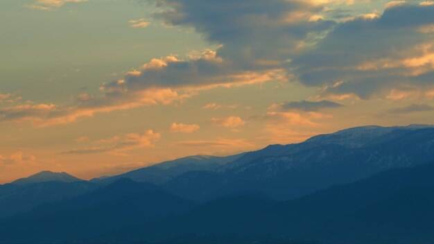 Las montañas en la silueta del atardecer en el cielo naranja brillante paisaje de montaña pan