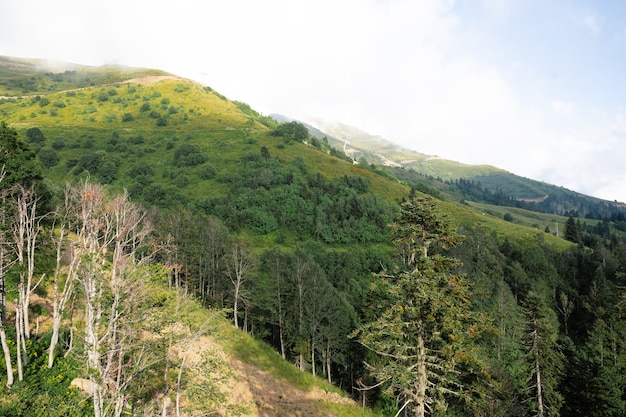 Montañas verdes escénicas y hermosas nubes del cielo para el fondo