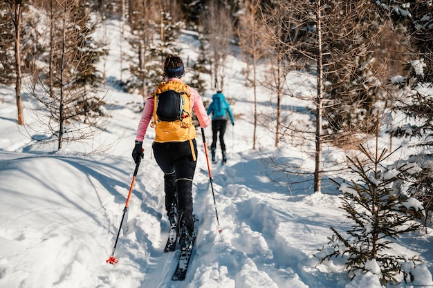 Foto montañero esquí de travesía caminar esquí alpinista en las montañas esquí de travesía en paisaje alpino con árboles nevados aventura deporte de invierno