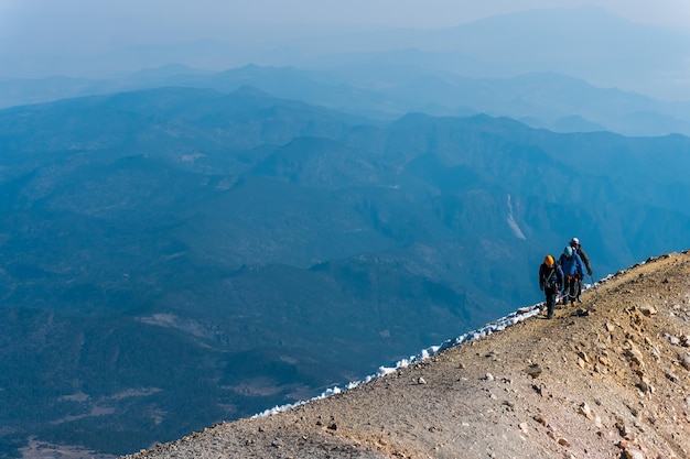 Montañeros caminando sobre el cráter del volcán