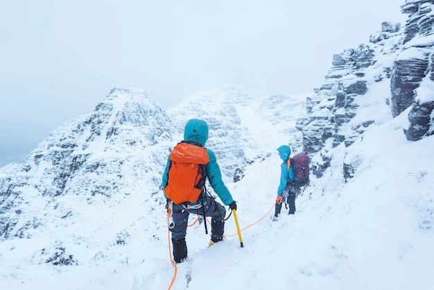 Montañeros subiendo un nevado Liathach Ridge en Escocia