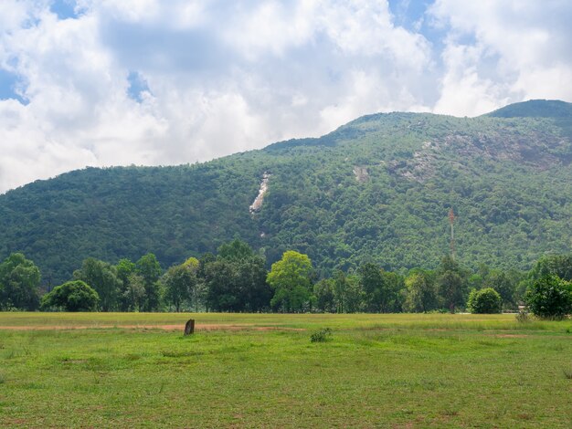 Montanha com campo de grama verde e céu nublado na província de Ranong, Tailândia