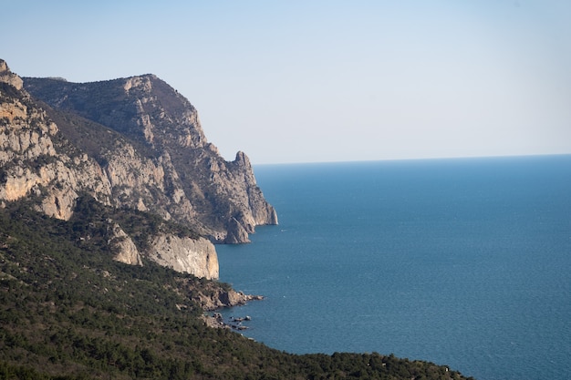 Montanha, costa do mar, vista aérea do oceano, as árvores crescem nas margens do infinito mar azul ...