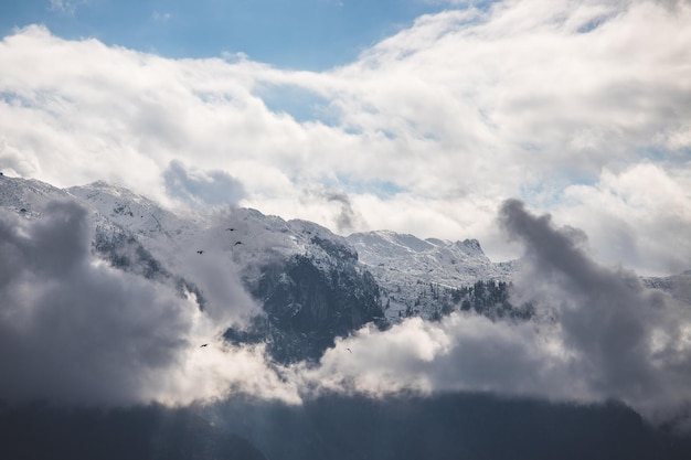 Foto montanha de neve untersberg com nuvens de neve e céu azul áustria