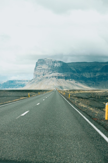 Montanha maciça com desfiladeiro na Islândia fim de uma estrada infinita Vista da estrada durante uma viagem pelas áreas selvagens da Islândia Boho mochila estilo viagem conceito de fundo da natureza Colorido
