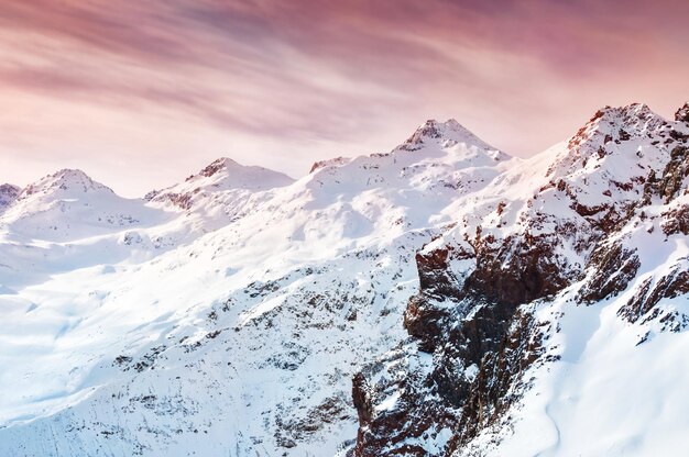 Montanhas cobertas de neve de inverno ao pôr do sol. Efeito de tonificação criativo. Linda paisagem de inverno