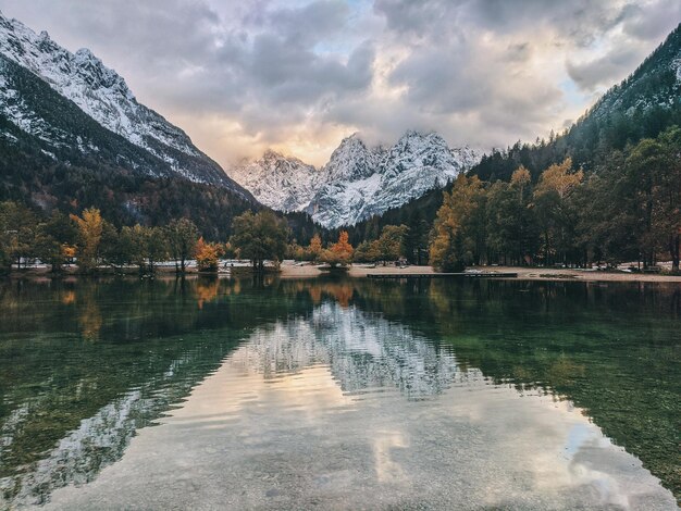 Montanhas dos Alpes do outono na luz do dia refletida nas águas do lago verde Jasna, Kranjska Gora. Eslovênia