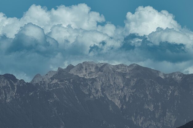 Foto montanhas majestosas abraçadas por nuvens etéreas uma imagem de arte cativante que retrata a beleza sublime da natureza