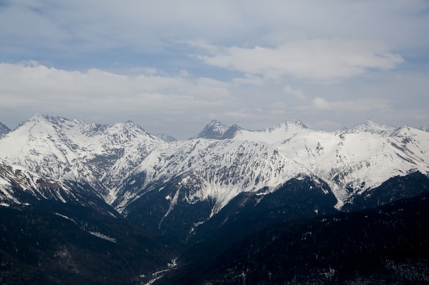 Montanhas na neve contra o céu nas nuvens