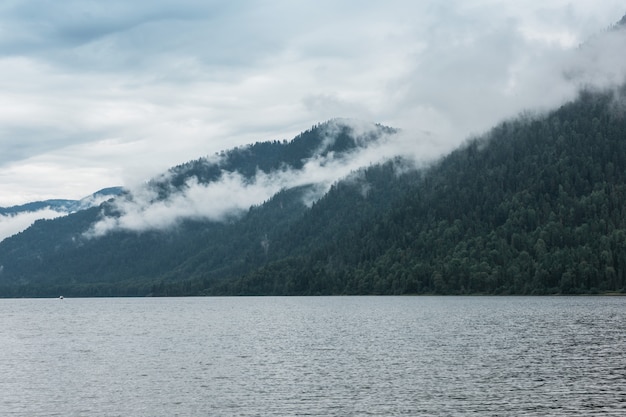 Montanhas nevoentas perto do lago